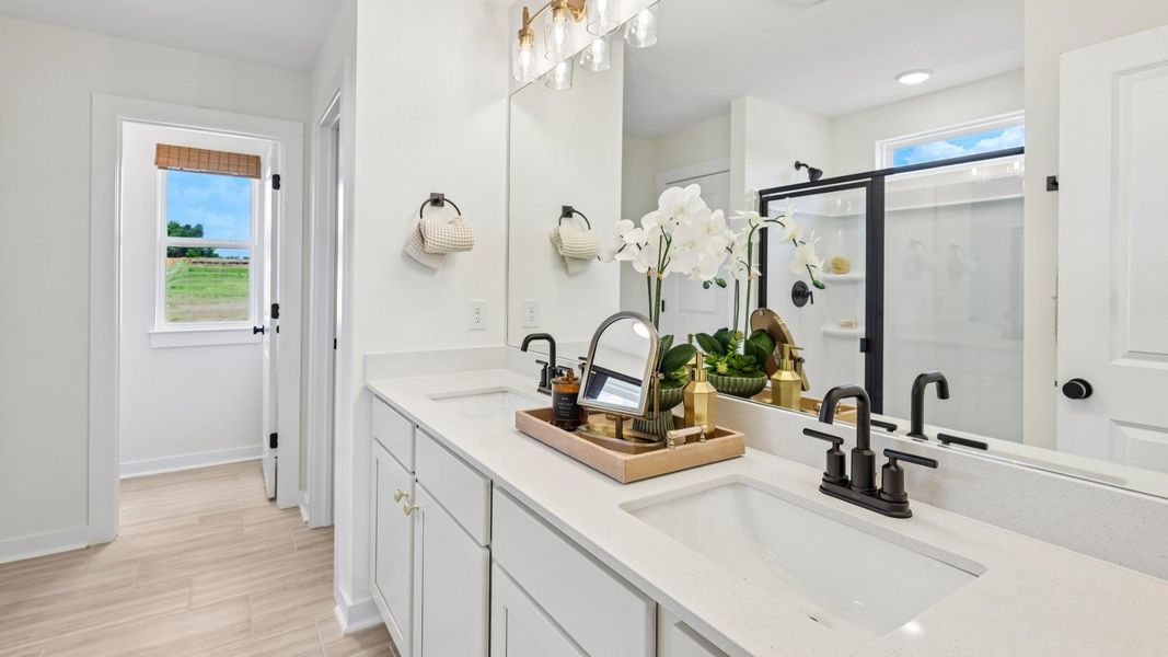 Primary bathroom with dual vanity and glass enclosed