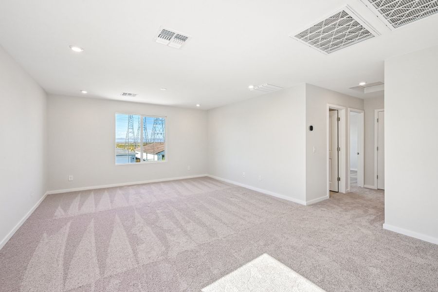A large empty room with a carpet.