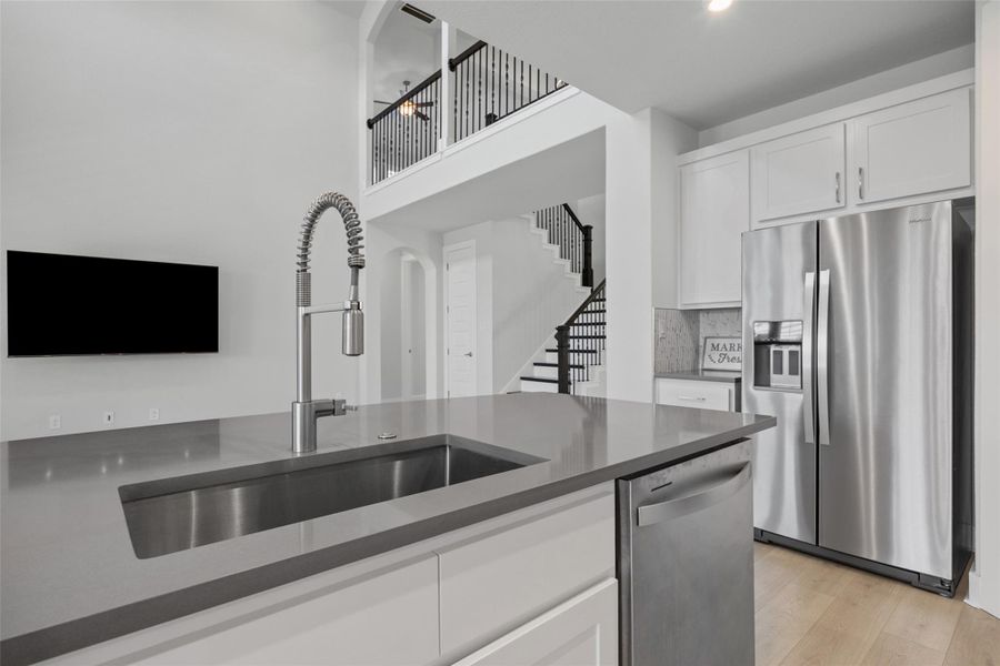 A pristine kitchen island with a sleek sink and modern appliances anchors this airy, open-concept living space.