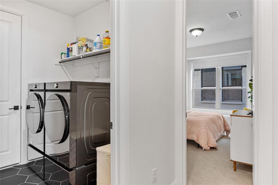 Washroom featuring visible vents, laundry area, and washer and clothes dryer