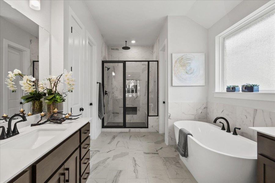 Full bathroom with a marble finish shower, marble finish flooring, vanity, a freestanding bath, and recessed lighting Full bathroom with a marble finish shower, marble finish flooring, vanity, a freestanding bath, and recessed lighting