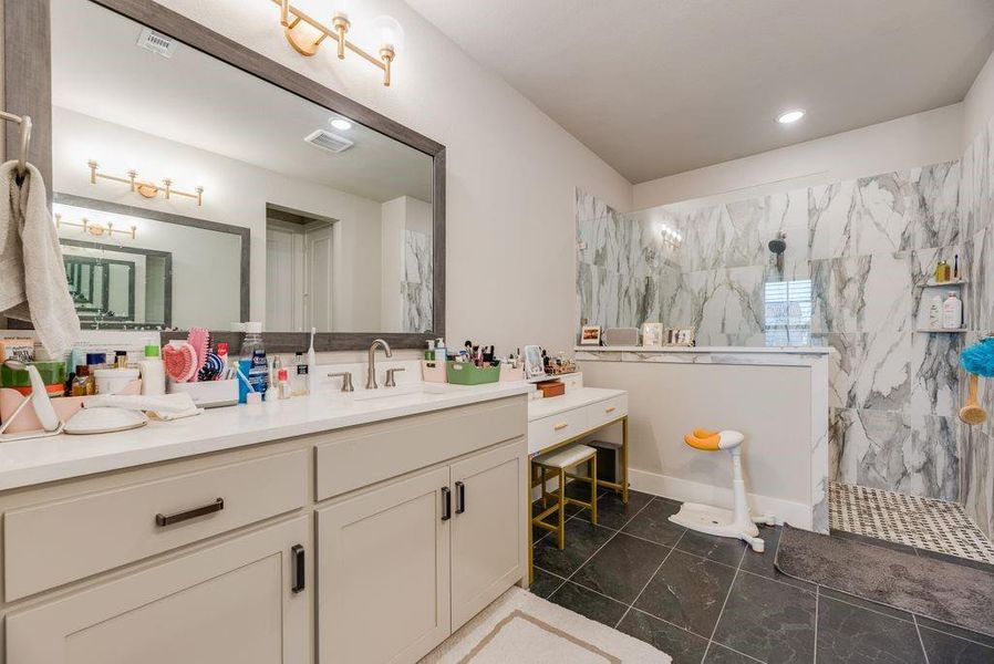 Full bath featuring vanity, a marble finish shower, and recessed lighting