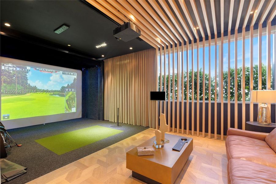 Recreation space featuring a projection screen, custom wood-slat ceiling and wall detailing, and light-tone wood parquet flooring