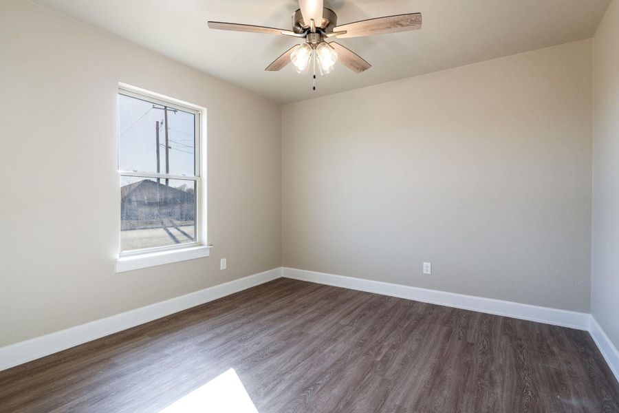 Spare room featuring dark wood-style floors and ceiling fan