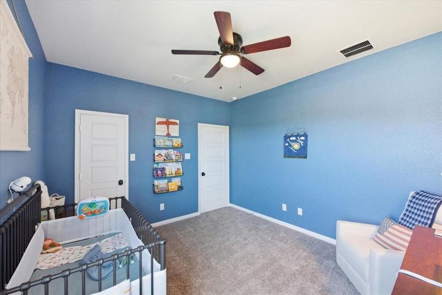 Carpeted bedroom with a ceiling fan Carpeted bedroom with a ceiling fan