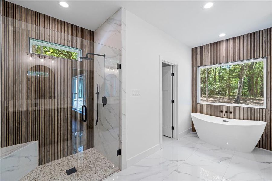 bathroom features a wood style tile, natural light, walk in shower, a freestanding bath, marble tiled flooring, and recessed lighting bathroom features a wood style tile, natural light, walk in shower, a freestanding bath, marble tiled flooring, and recessed lighting