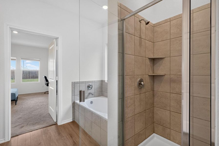 Luxurious bathing quarters await with a soaking tub and separate glass-enclosed shower. Luxurious bathing quarters await with a soaking tub and separate glass-enclosed shower.