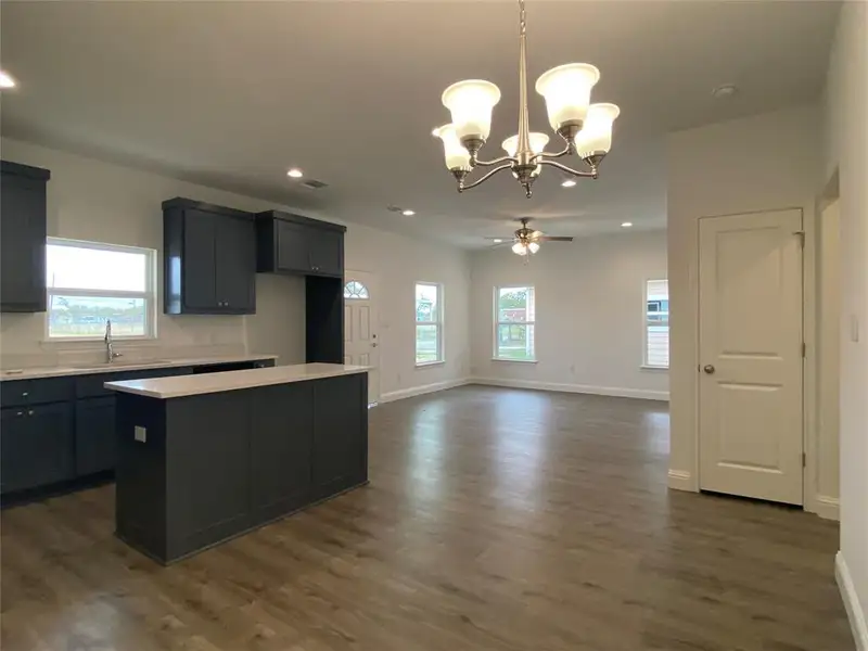 Kitchen featuring pendant lighting, a chandelier, a center island, healthy amount of natural light, and recessed lighting Kitchen featuring pendant lighting, a chandelier, a center island, healthy amount of natural light, and recessed lighting