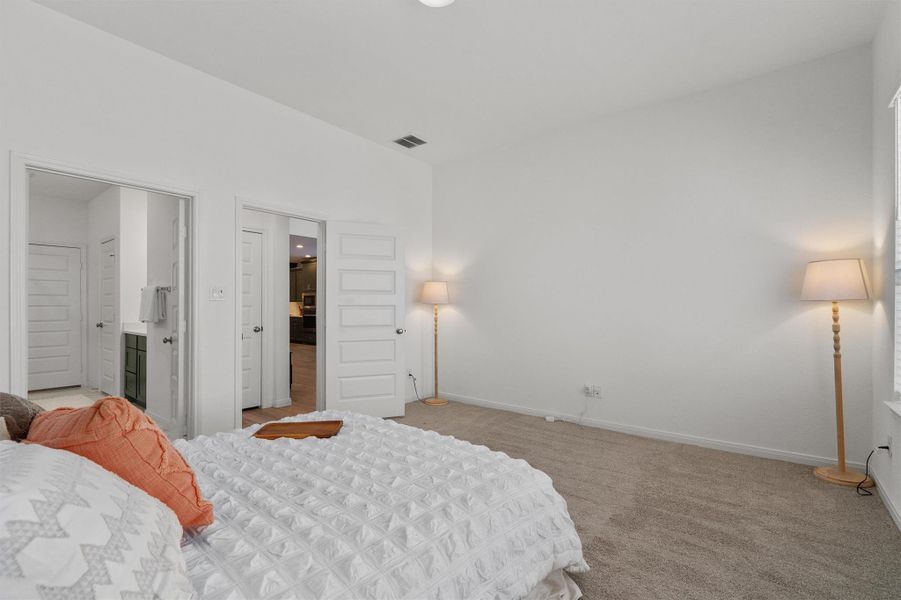 Bedroom with light colored carpet and ensuite bathroom