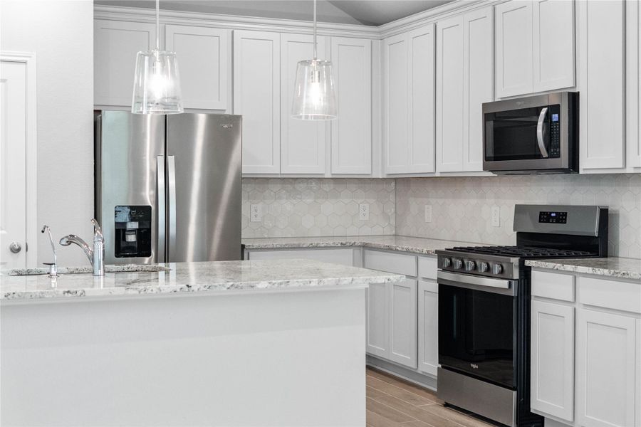 Welcome to the heart of the home, a modern, highly functional kitchen that perfectly balances style and utility. Granite countertops, complemented by a stylish backsplash, shaker-style cabinets provide ample storage, and the Whirlpool stainless steel appliances are all features of this beautiful kitchen!