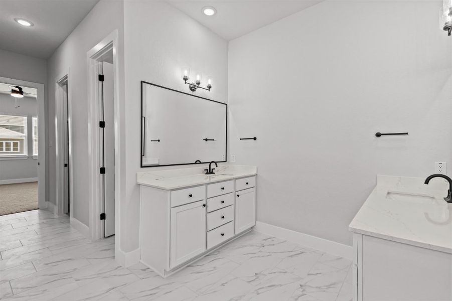 A bathroom with white cabinets.