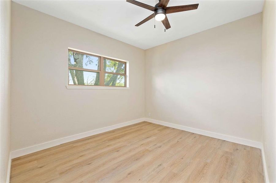 Empty room featuring wood finished floors and a ceiling fan Empty room featuring wood finished floors and a ceiling fan