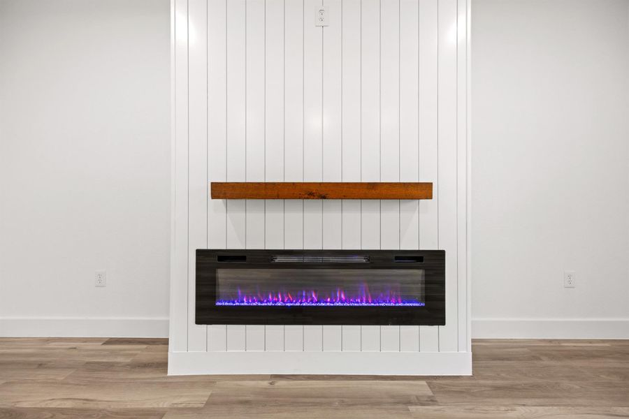 Detailed view of wood finished floors and a glass covered fireplace