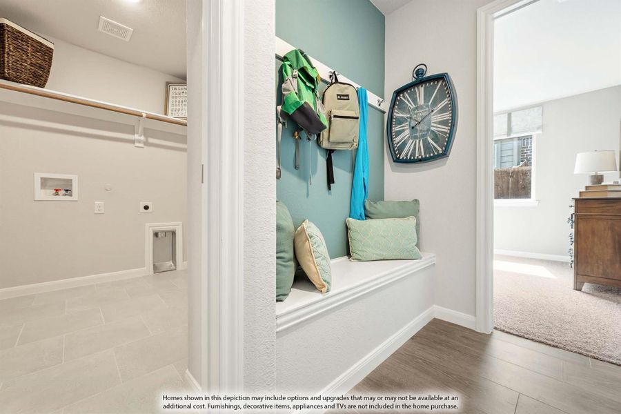 Mudroom with built-in bench, wall hooks for backpacks, and teal accent wall next to laundry room with tile floor Mudroom with built-in bench, wall hooks for backpacks, and teal accent wall next to laundry room with tile floor