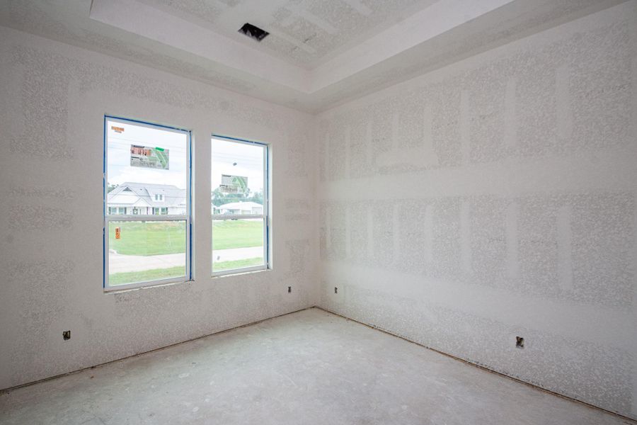 Bright, unfinished bedroom with large windows offering ample natural light and views of the neighborhood, ready for your personal touch. Bright, unfinished bedroom with large windows offering ample natural light and views of the neighborhood, ready for your personal touch.