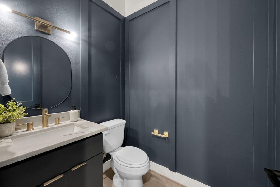 Stylish powder room with contrasting vanity and gold accents. Stylish powder room with contrasting vanity and gold accents.