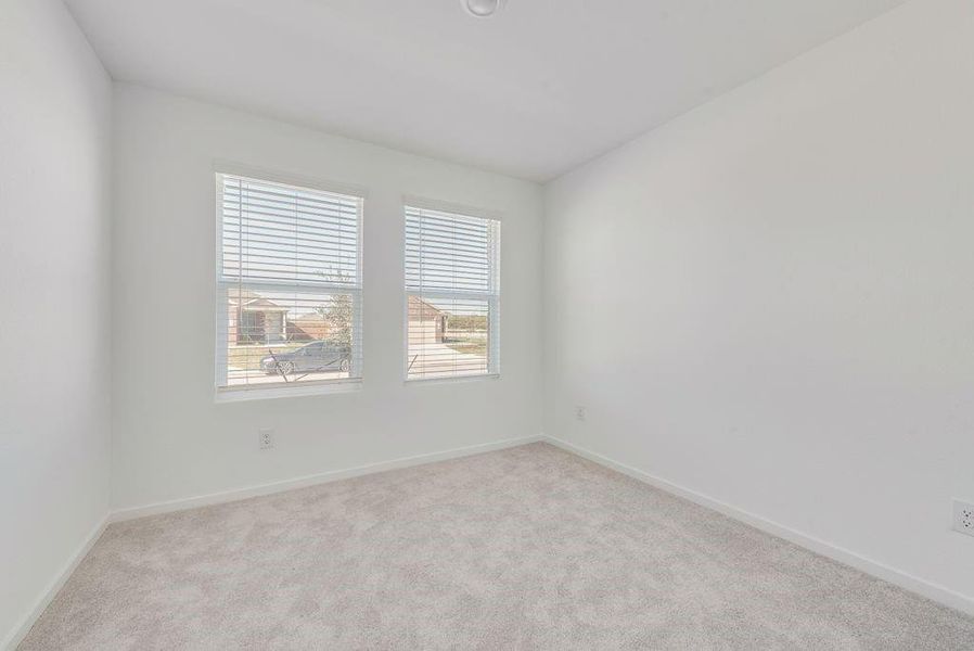 Empty room featuring light carpet and baseboards