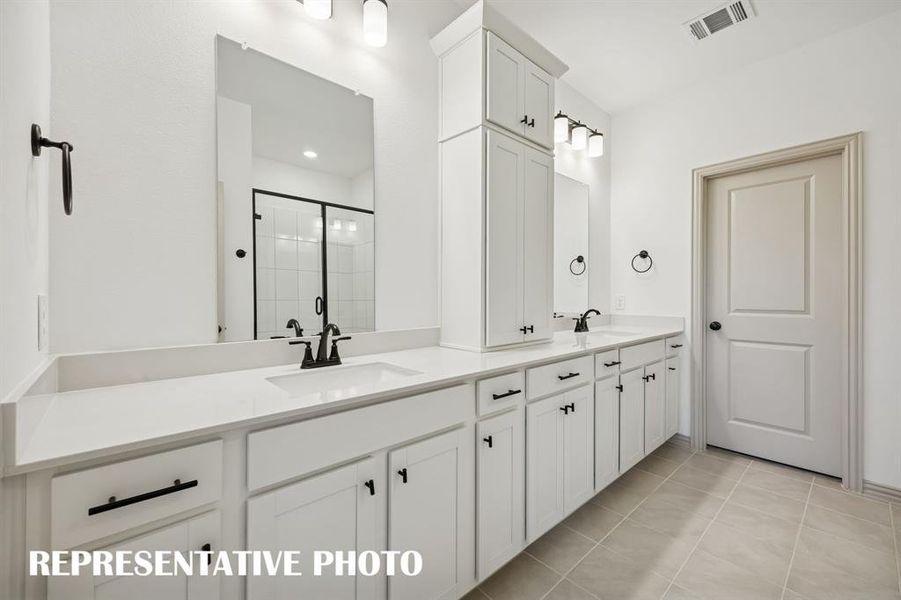 You'll enjoy ample room for two and fantastic storage space in this lovely owner's bath.  REPRESENTATIVE PHOTO