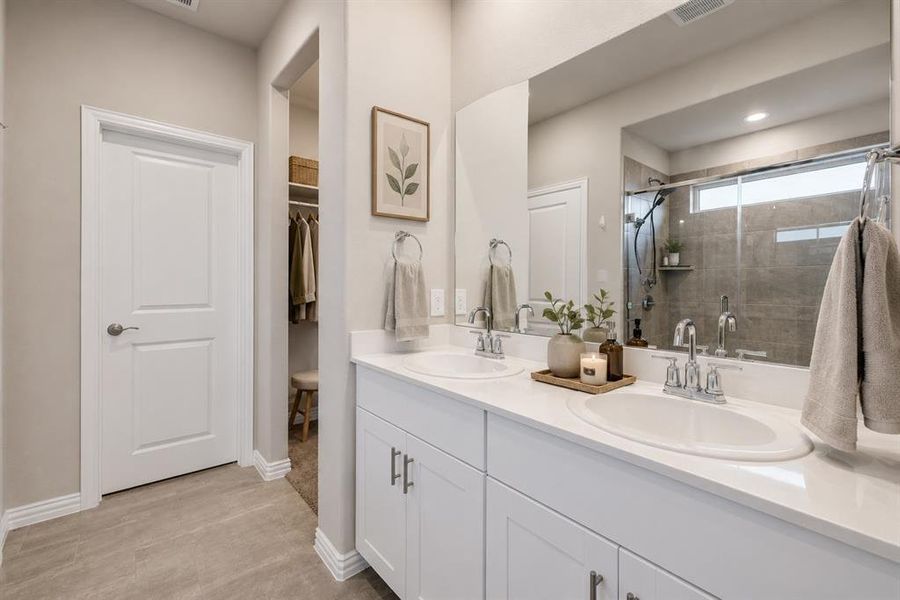 *Virtually Staged* Bathroom featuring a dual vanity with white cabinetry and integrated sinks, a full-width mirror, and chrome fixtures