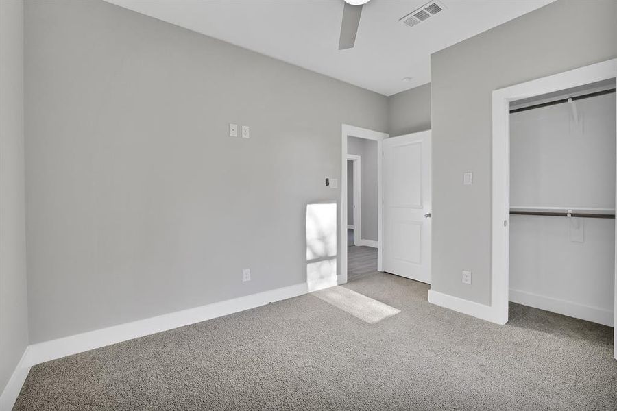 Unfurnished bedroom with ceiling fan, a closet, and carpet