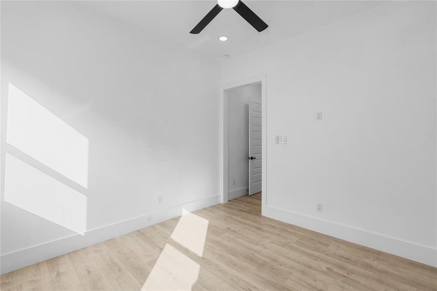 Empty room featuring light wood-type flooring, ceiling fan, and recessed lighting Empty room featuring light wood-type flooring, ceiling fan, and recessed lighting