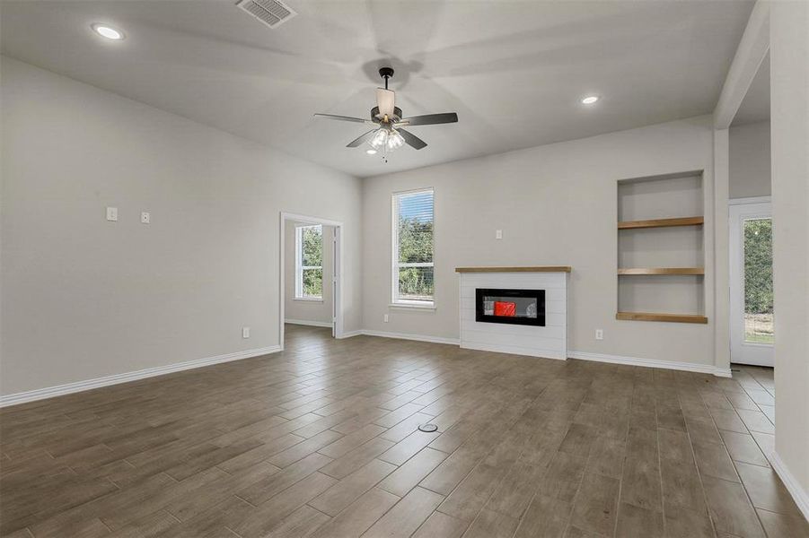 Unfurnished living room with wood-type flooring and ceiling fan