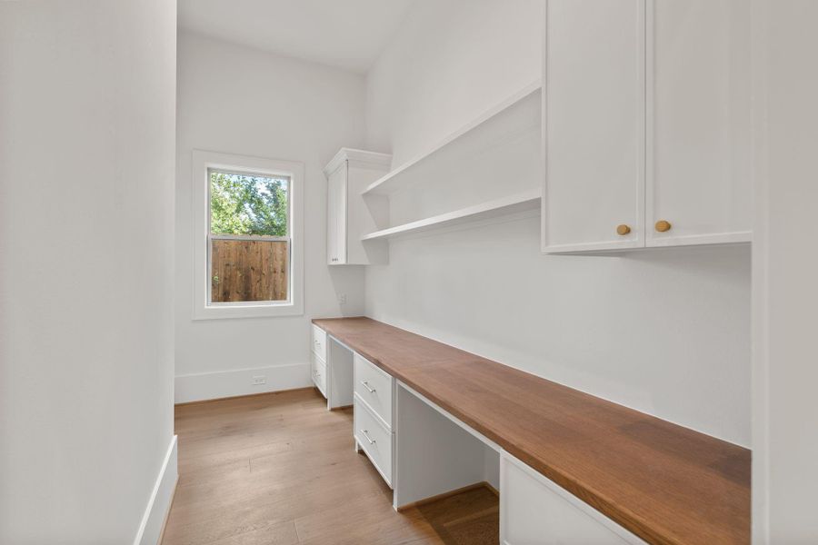 A functional workspace provides additional built-in storage and workspace, complete with cabinetry, drawers, and shelving to keep everyday essentials organized.