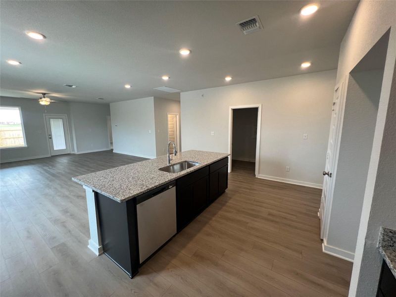 A contemporary kitchen island with granite counters anchors this spacious, open-concept living area.