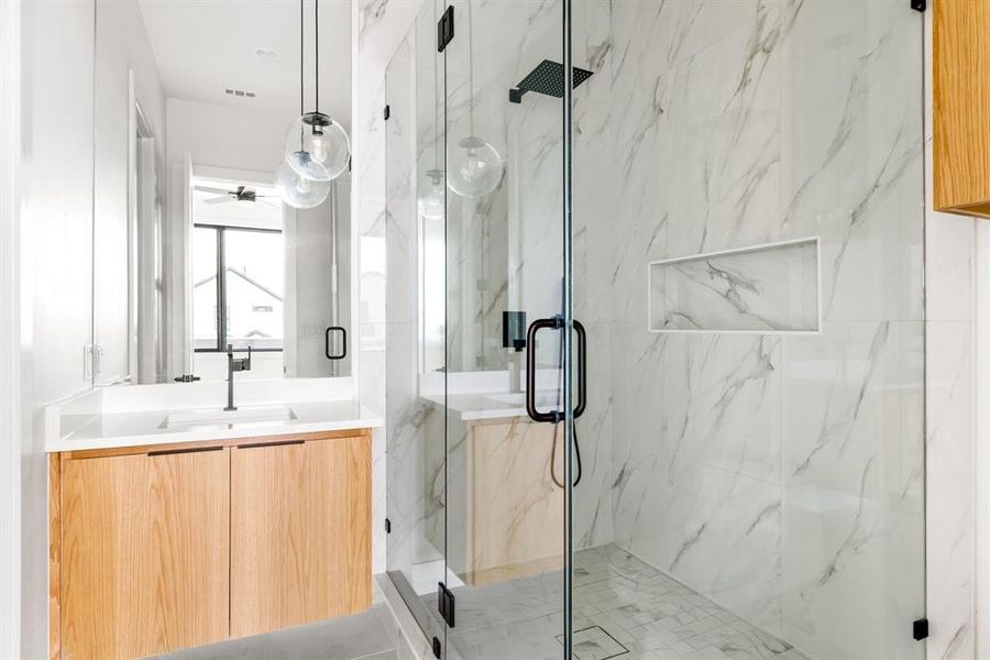 Full bath with a marble finish shower, vanity, and ceiling fan Full bath with a marble finish shower, vanity, and ceiling fan