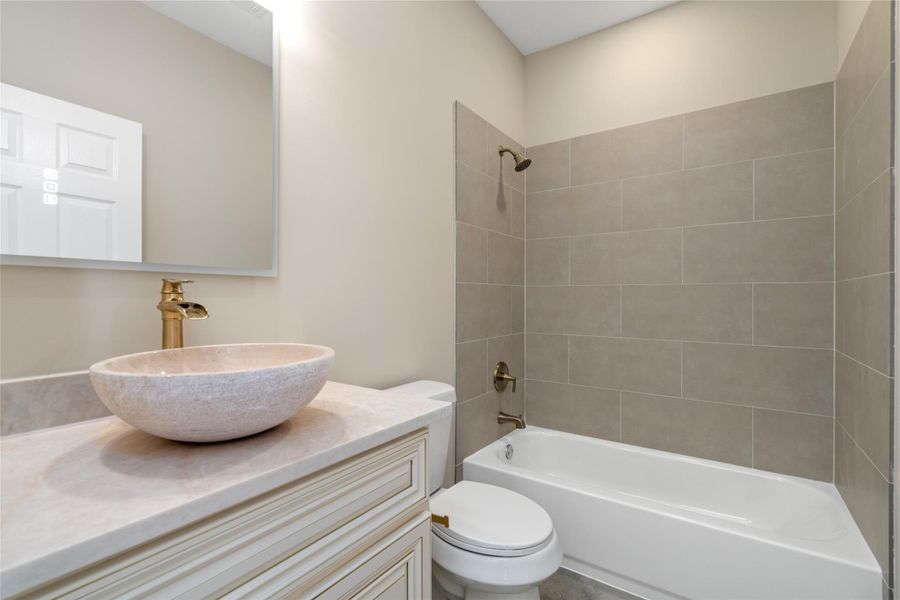 Full guest or secondary bathroom with stylish vessel sink and contemporary tilework. Functional yet beautifully designed.
