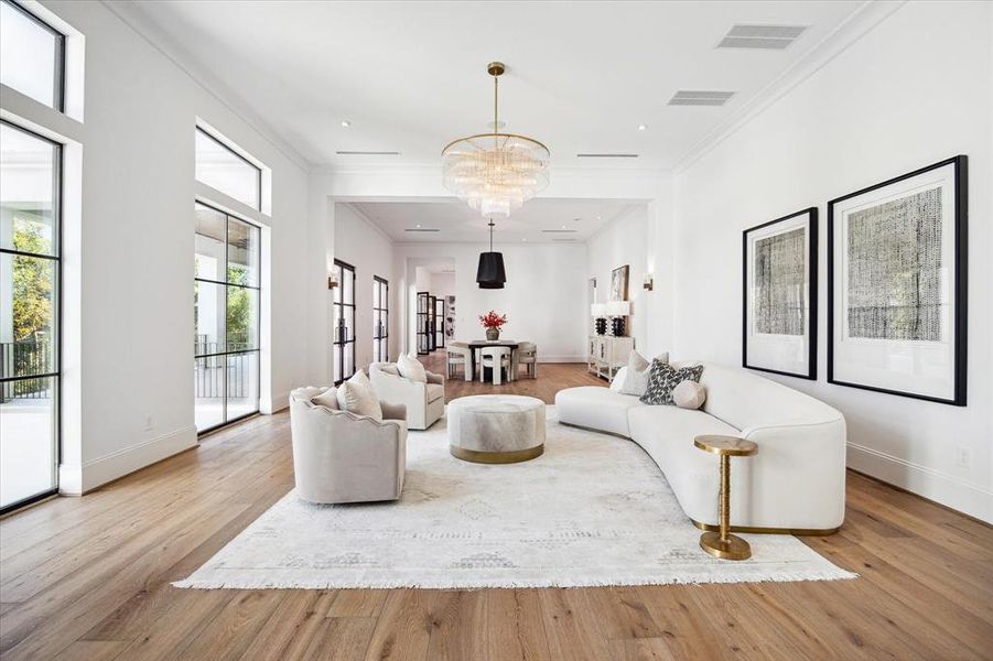 The great room is illuminated by a striking chandelier, creating a warm and inviting atmosphere. Perfect for entertaining, it seamlessly connects to the dining room and wet bar, offering a smooth flow for guests. This open layout makes hosting gatherings both stylish and effortless.