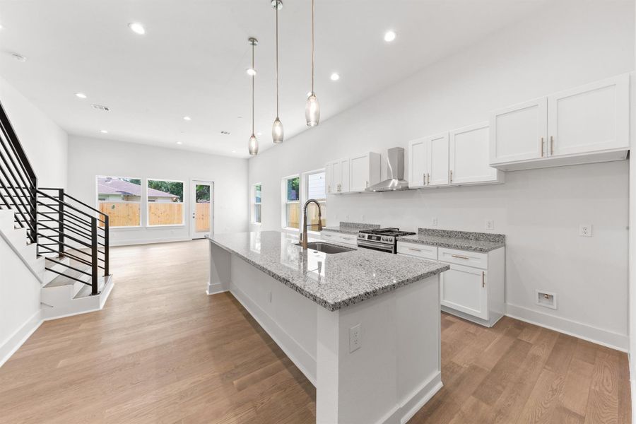 High ceilings enhance this space, highlighted by stylish pendant lights and recessed canned lighting for a bright, modern feel.