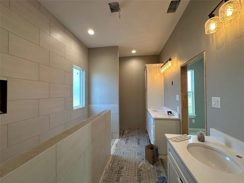 Bathroom with tile patterned flooring, vanity, and tile walls