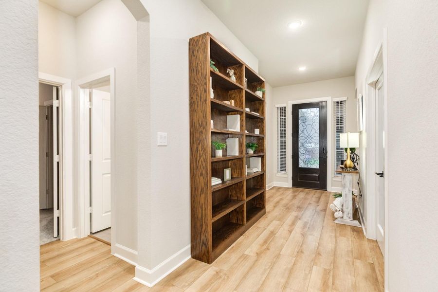 This beautiful entrance into this home has a magnificent glass and wooden door and luxury HV wooden floors. As you enter on your right, you have your mud room, laundry room and entrance to the extended double garage. On the left, you have 2 bedrooms and a bath.