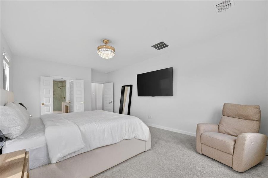 Spacious bedroom featuring light gray carpeting and white walls