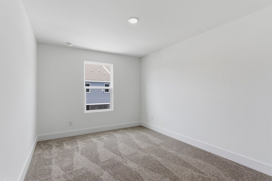 A room with a window and a rug.
