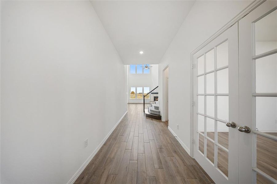 Hall with dark wood-style floors, stairway, french doors, and recessed lighting Hall with dark wood-style floors, stairway, french doors, and recessed lighting