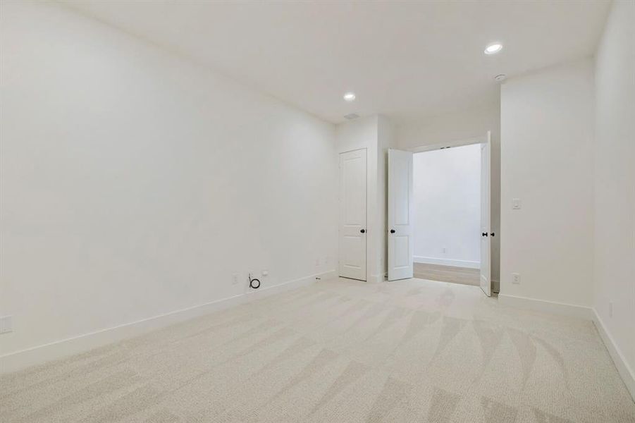 Carpeted interior room featuring neutral wall tones, recessed lighting, and white trim Carpeted interior room featuring neutral wall tones, recessed lighting, and white trim