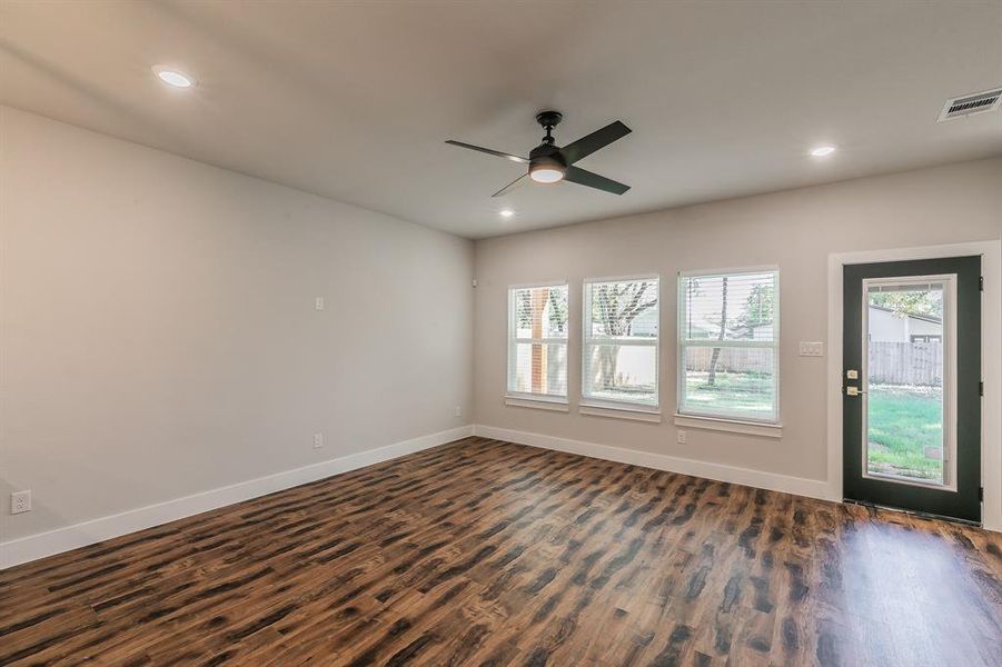 Empty room with ceiling fan and dark wood-type flooring