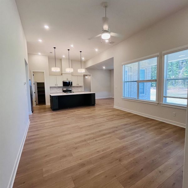Vaulted ceilings, wood-finish flooring, recessed lighting, ceiling fan, and large windows with blinds Vaulted ceilings, wood-finish flooring, recessed lighting, ceiling fan, and large windows with blinds