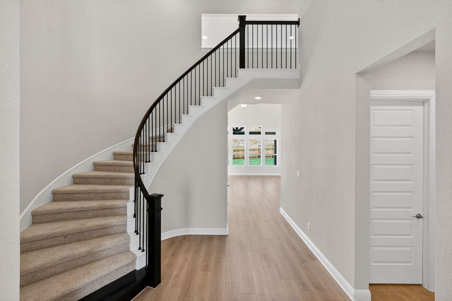 Stairs featuring wood finished floors and a high ceiling Stairs featuring wood finished floors and a high ceiling
