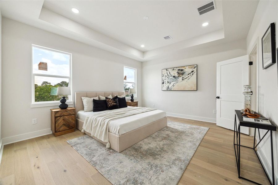 Experience serene comfort in this spacious primary bedroom, featuring abundant natural light, elegant tray ceilings, and stylish decor. Perfect for relaxation and rejuvenation. Experience serene comfort in this spacious primary bedroom, featuring abundant natural light, elegant tray ceilings, and stylish decor. Perfect for relaxation and rejuvenation.