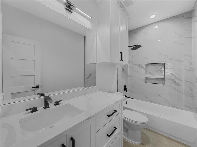 Full bath featuring shower / bathtub combination, vanity, recessed lighting, and light wood-style floors Full bath featuring shower / bathtub combination, vanity, recessed lighting, and light wood-style floors