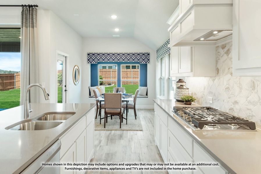 Kitchen with white cabinets, quartz counters, gas cooktop, and dining nook with backyard views