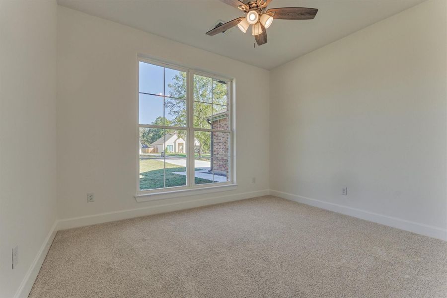 Secondary bedroom #2 features natural lighting, plush carpeting, and a ceiling fan. Secondary bedroom #2 features natural lighting, plush carpeting, and a ceiling fan.