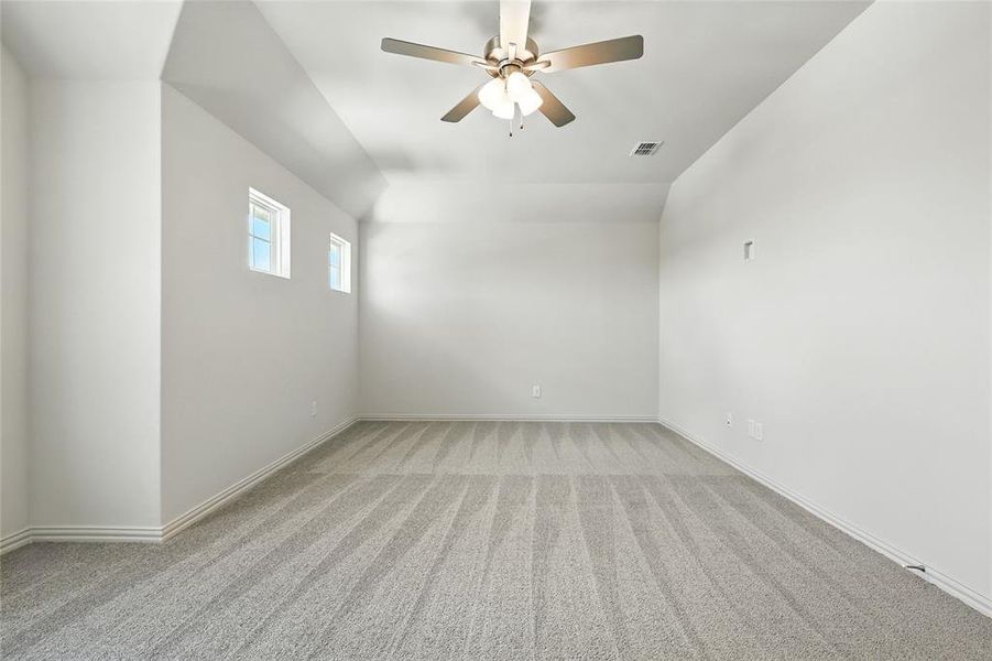 Carpeted empty room featuring a ceiling fan and baseboards Carpeted empty room featuring a ceiling fan and baseboards