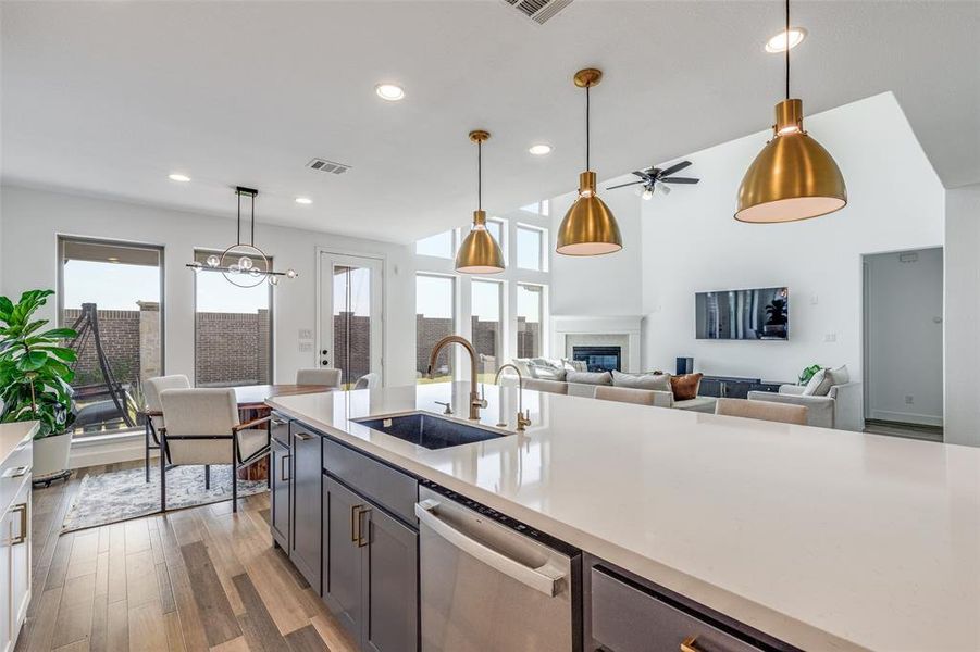 Kitchen with decorative light fixtures, light wood finished floors, dishwasher, recessed lighting, and open floor plan