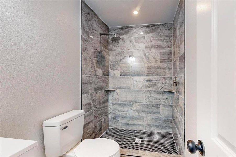 Bathroom with toilet and tiled shower