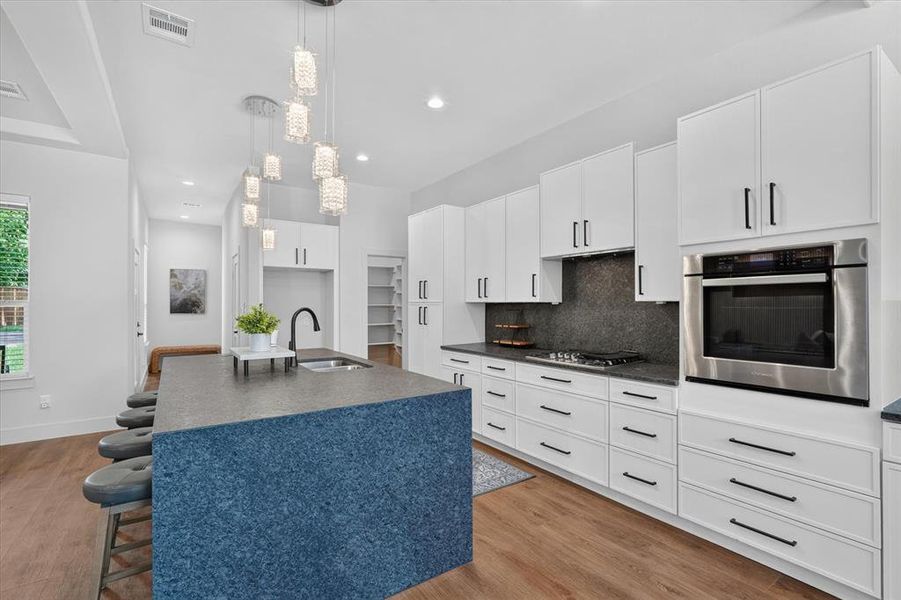 Modern kitchen with a dark blue speckled island and white shaker-style cabinetry