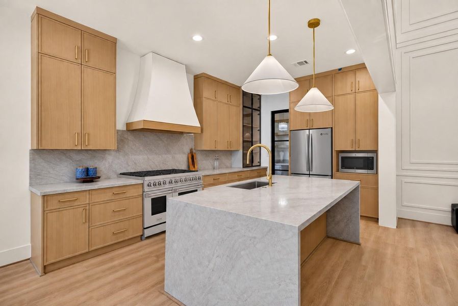 This beautifully designed kitchen pairs warm wood cabinetry and elegant stone surfaces with a ZLINE professional range, GE Profile 4-door French-door refrigerator, and GE microwave, creating a polished, high-end space ready for everyday living and entertaining. This beautifully designed kitchen pairs warm wood cabinetry and elegant stone surfaces with a ZLINE professional range, GE Profile 4-door French-door refrigerator, and GE microwave, creating a polished, high-end space ready for everyday living and entertaining.